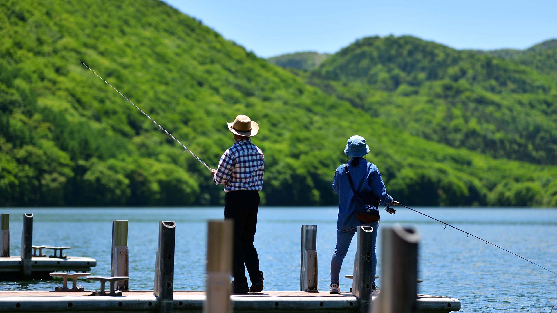 初夏の湖畔で釣りをする夫婦